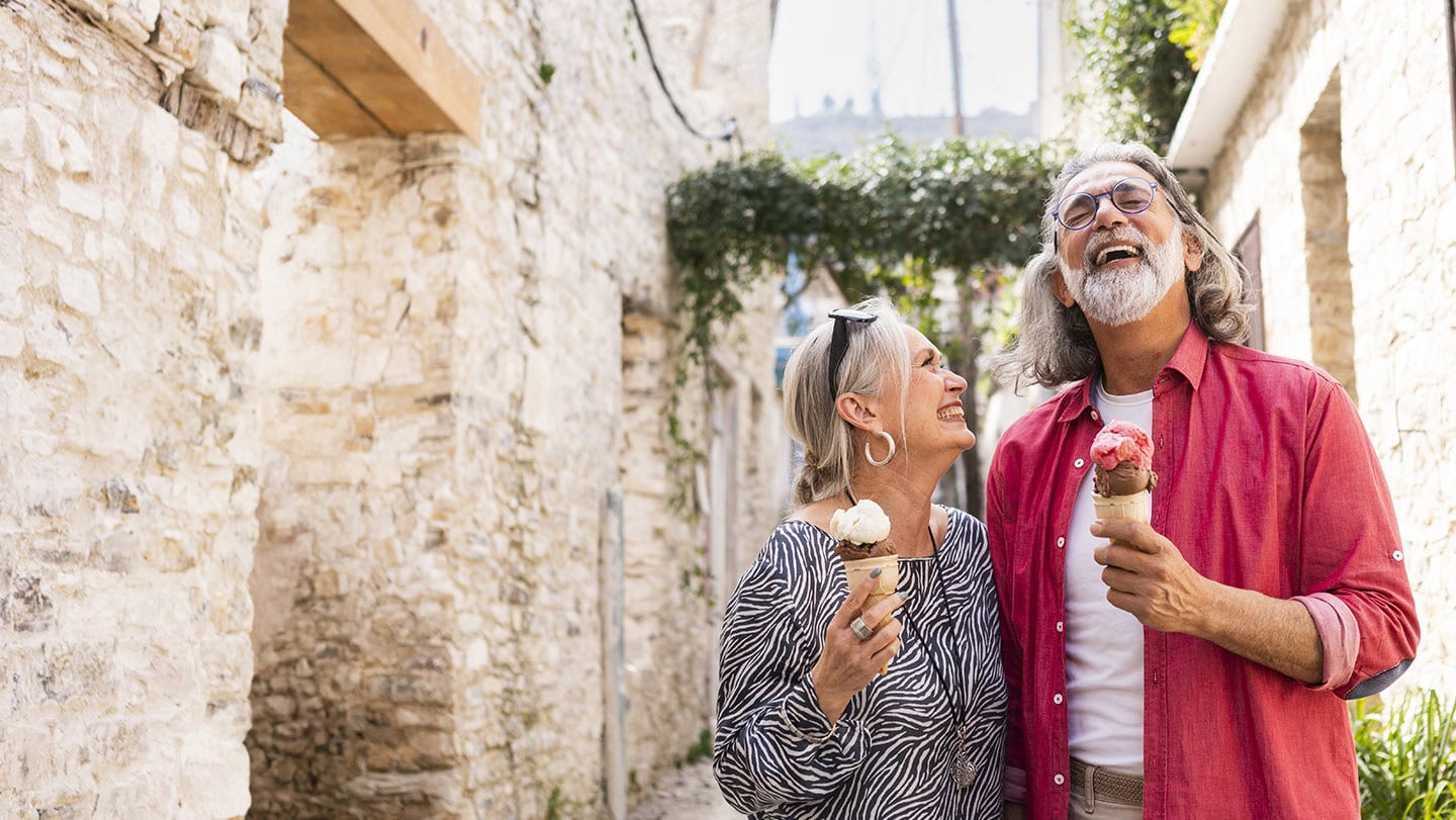 Mature tourists enjoying local ice cream while walking through an old town in Cyprus